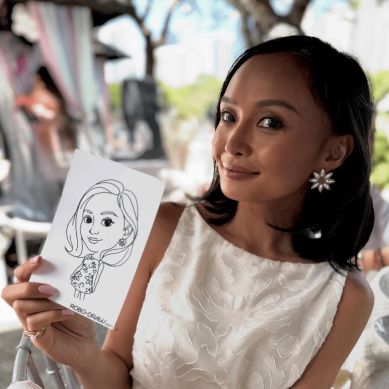 Woman holding her live caricature portrait at a Robo-Draw brand activation